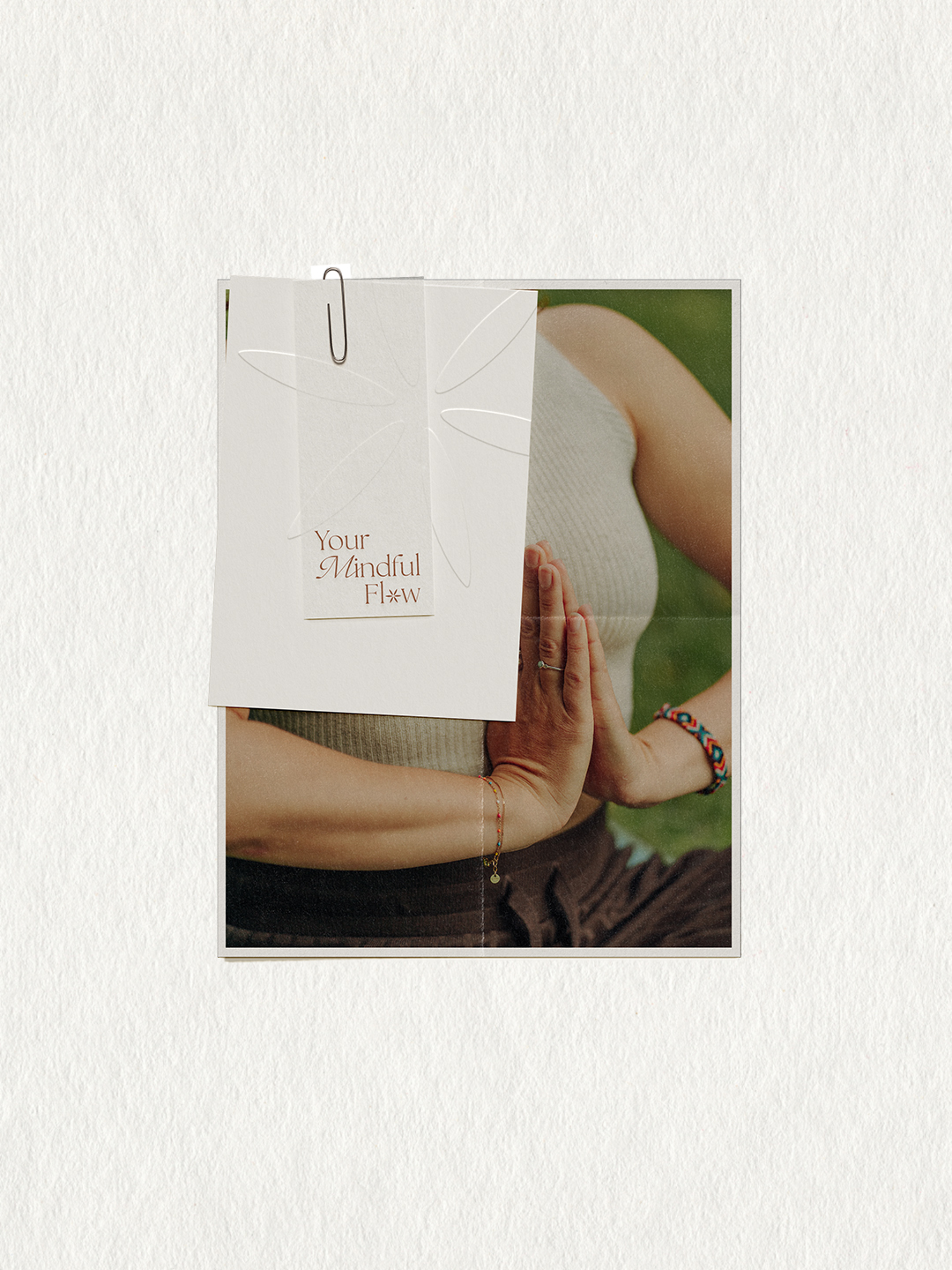 Papierkarte mit dem Logo von Your Mindful Flow vor einer Person mit Händen in Gebetshaltung